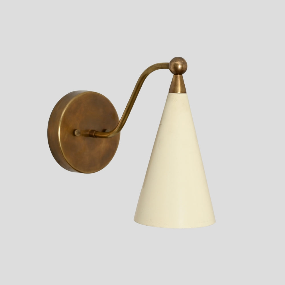 Wall-mounted lamp with brass arm and cream conical shade on a light gray background