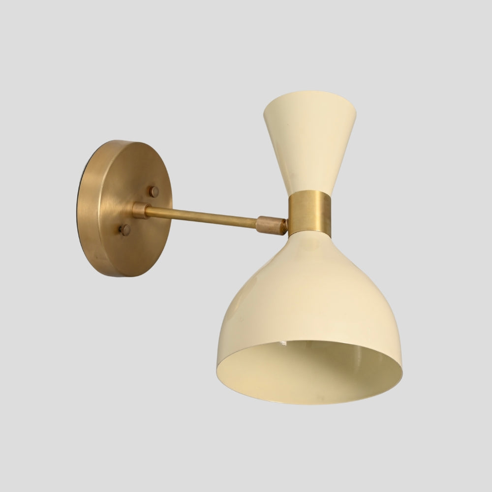 Wall-mounted light fixture with brass and cream lampshade on a gray background