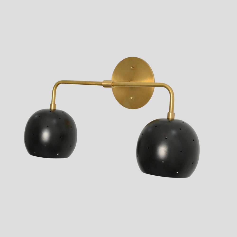 Vanity light fixture featuring a combination of brass and black finishes with spherical ball shades, offering a modern, stylish contrast suitable for bathrooms or dressing areas.