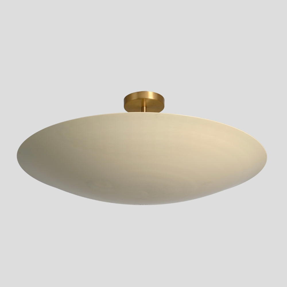 Ceiling light fixture with beige shade and gold fixture on a light gray background