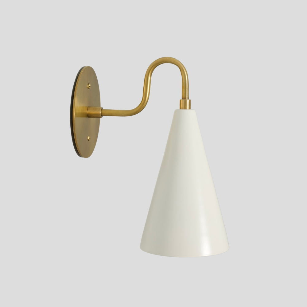 Brass cone wall sconce with matte white perforated shade, modern mid-century wall light.