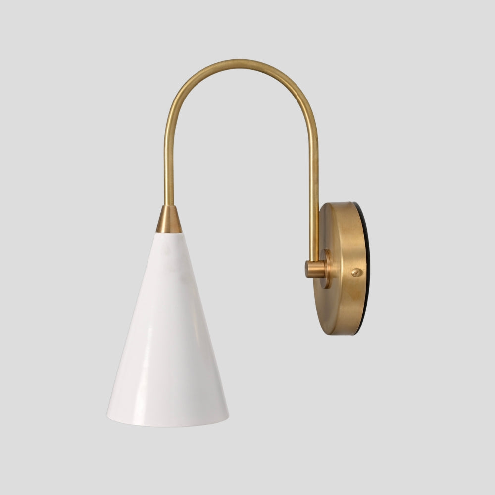Wall-mounted lamp with white cone shade and brass curved arm on a light gray background