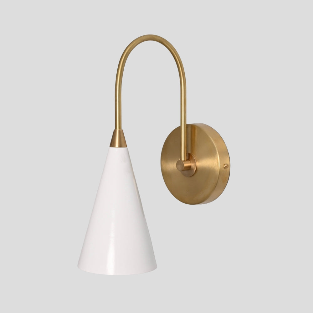 Long arm white cone wall sconce in raw brass mounted on gray background