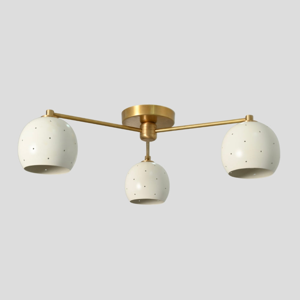 Flush mount ceiling light with three arms, each holding a white spherical shade, creating a balanced, modern design with soft, diffused lighting.