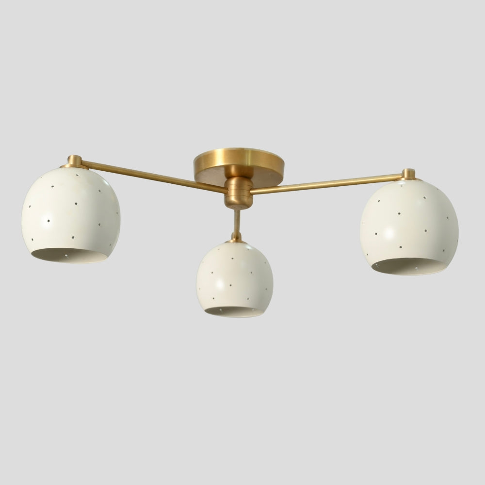 Flush mount ceiling light with three arms, each holding a white spherical shade, creating a balanced, modern design with soft, diffused lighting.