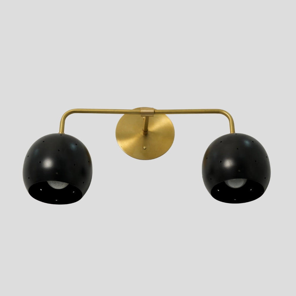 Vanity light fixture featuring a combination of brass and black finishes with spherical ball shades, offering a modern, stylish contrast suitable for bathrooms or dressing areas.